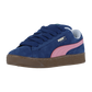 Der Puma Suede XL ist ein Retro-Sneaker in Persian Blue-Gum mit marineblauem Wildleder, rosa Streifen, goldenem Branding, marineblauen Schnürsenkeln und brauner Sohle, die schräg auf einem weißen Hintergrund abgebildet ist.