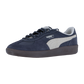 Der Puma Palermo Pop Retro-Sneaker in Marineblau hat ein weißes Logo und Streifen, eine schwarze Sohle und ein graues Innenfutter. Er ist Teil der kultigen Terrace-Kollektion und steht auf weißem Grund.