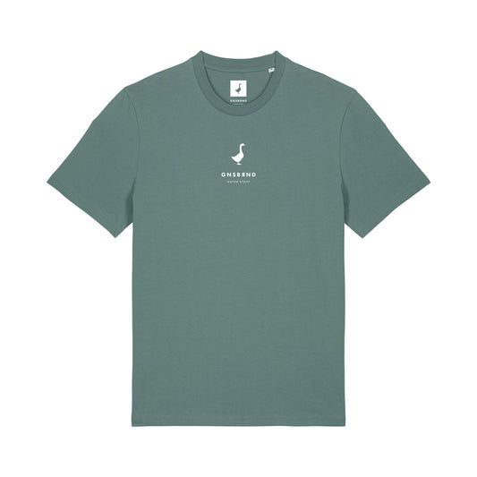 Das Liebesdorf Shirt von GNSBRND ist ein grünes Unisex-Kurzarm-T-Shirt mit kleinem weißen Logo und "GNSSSND Seven Stories" mittig auf der Brust, Schwanen-Emblem über dem Text, Halsausschnitt-Anhänger und aus weicher Bio-Baumwolle.