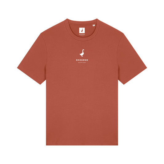 Das Liebesdorf Shirt von GNSBRND ist ein rostfarbenes T-Shirt mit weißem "ONS&OND" Brustaufdruck. Es ist aus Bio-Baumwolle gefertigt, hat eine Unisex-Passform, einen Rundhalsausschnitt und ein kleines Etikett am Halsausschnitt.