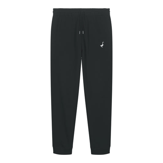 Die Hornberg Sweatpants von GNSBRND ist eine schwarze Unisex-Jogginghose mit elastischem Bund, verstellbarem Kordelzug, seitlichen Taschen, gerippten Knöchelbündchen und einem kleinen weißen Vogellogo. Hergestellt aus fair produziertem Bio-Baumwolle Joggpant Material.