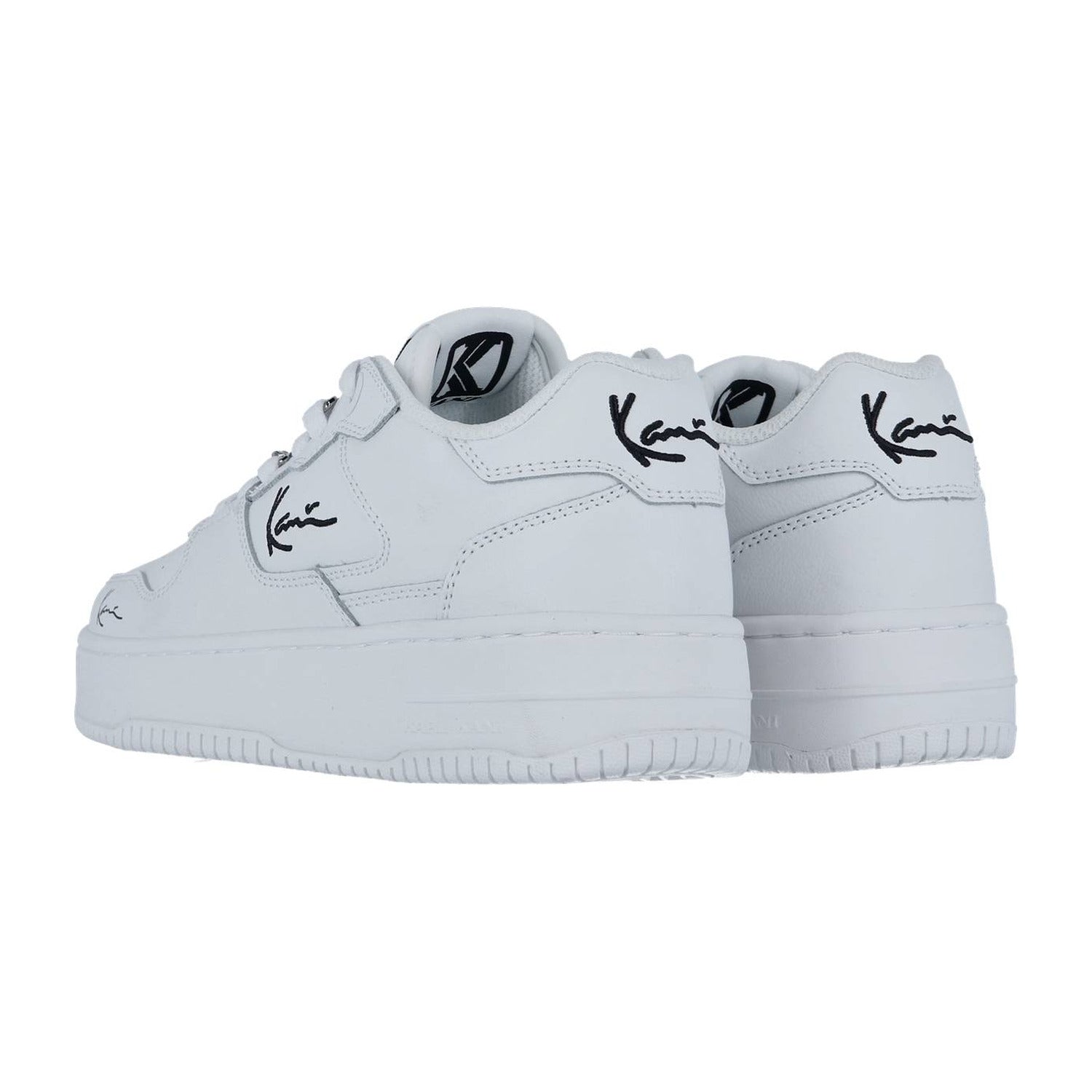 Die weiß/schwarzen Karl Kani 89 UP 23 MC WMN Sneakers haben eine dicke Sohle, ein schwarzes Logo mit Signatur an der Seite und der Ferse sowie ein rundes Emblem auf der Zunge. Diese weißen Low-Tops fangen Streetstyle-Vibes ein, die sowohl von der Seite als auch von hinten zu sehen sind.