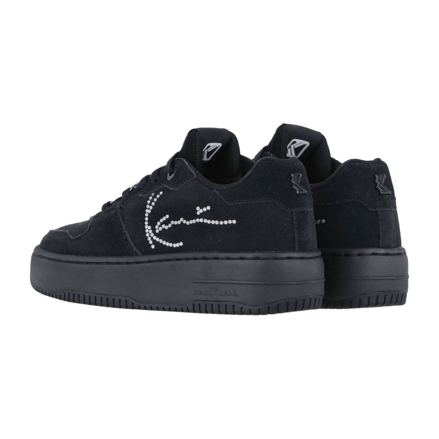 Die Karl Kani 89 Up Logo Prm Black Sneakers sind schwarze Low-Tops mit einem charakteristischen Strass-Design und dicken Sohlen, die von der Seite und von hinten gezeigt werden - ideal, um jedem Outfit Streetwear-Flair zu verleihen.