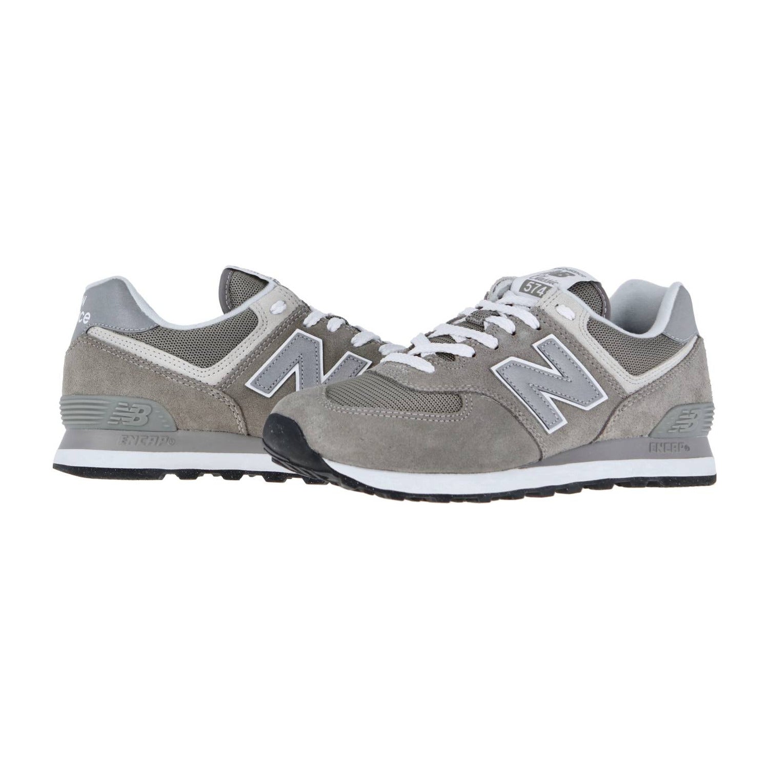 Die New Balance ML574V3 Retro-Sneaker haben ein graues Obermaterial aus Mesh und Wildleder, weiße Schnürsenkel, ein charakteristisches N-Logo an der Seite und die ENCAP-Technologie für Komfort und Unterstützung, dargestellt auf weißem Hintergrund.