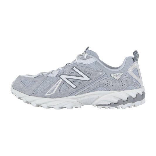 Der New Balance ML610TV1 ist ein hellgrauer Trail-Sneaker mit weißen Akzenten, einer klobigen weiß-grauen Sohle mit ABZORB-Zwischensohle, Obermaterial aus Mesh und Wildleder und dem charakteristischen "N"-Logo an der Seite (von links).