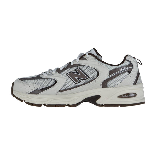 Der New Balance MR530 ist ein weißer und grauer Retro-Running-Sneaker mit schwarzen und silbernen Akzenten, Mesh-Einsätzen und einer klobigen Gummisohle mit ABZORB-Dämpfung, hier von der Seite.