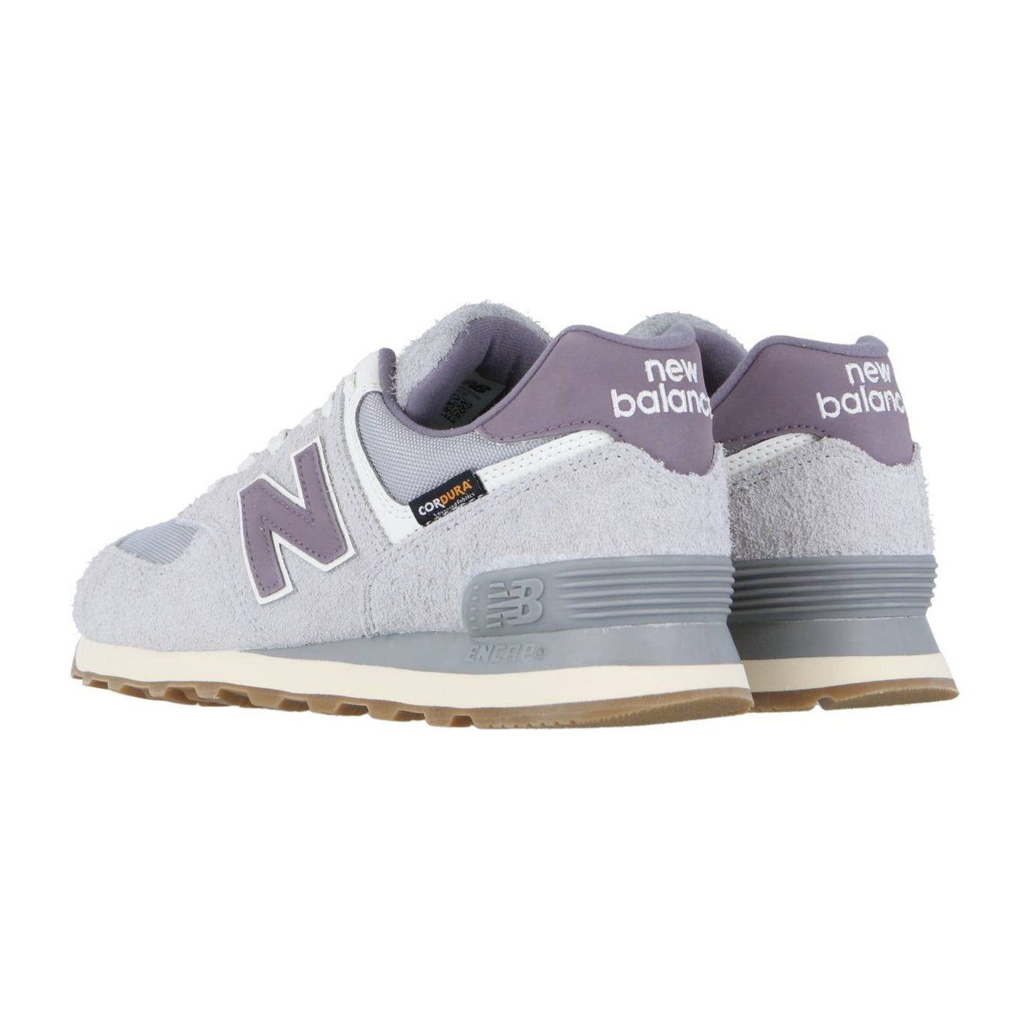 Ein Paar New Balance 574 V2 Turnschuhe in Hellgrau mit lila Akzenten und weißen Sohlen, mit ENCAP-Dämpfung, von der Seite und hinten auf einem weißen Hintergrund gezeigt. Das New Balance Logo erscheint an der Ferse und an der Seite.