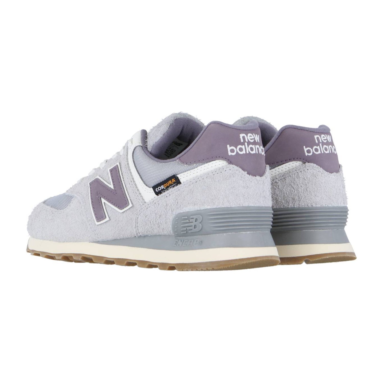 Ein Paar New Balance 574 V2 Turnschuhe in Hellgrau mit lila Akzenten und weißen Sohlen, mit ENCAP-Dämpfung, von der Seite und hinten auf einem weißen Hintergrund gezeigt. Das New Balance Logo erscheint an der Ferse und an der Seite.