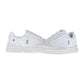 THE ROGER ADVANTAGE von On ist ein Paar weiße Low-Top-Sneaker mit dezenten grauen Akzenten, dem ON-Logo an der Seite, weißen Schnürsenkeln und einer dicken weißen Sohle, inspiriert von Roger Federers minimalistischem Sneaker-Stil.