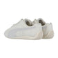 Die Puma Speedcat OG Sneakers in Off-White haben ein Wildleder-Finish, ein seitliches Puma-Logo und eine strukturierte beigefarbene Gummisohle, die angewinkelt gezeigt wird, um die Außenseiten und die Rückseite beider Schuhe zu betonen.