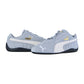 Die Puma Speedcat OG Sneakers haben ein hellgraues Design mit weißen Seitenstreifen, schwarzen Sohlen und goldenen Puma-Logos an den Seiten und auf der Zunge, die sich vor einem weißen Hintergrund präsentieren.