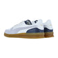 Puma Indoor Special Turnschuhe in Weiß und Marineblau mit goldenen Logo-Akzenten und Gummisohlen, von hinten und von der Seite auf weißem Hintergrund gezeigt. Diese retro-inspirierten Sneaker sind perfekt als stylische Hallenschuhe.