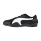 Puma Mostro OG Prime: Schwarzer Sport-Sneaker mit markantem weißem Seitenstreifen, strukturierter Gummisohle mit erhabenen Unebenheiten und einer niedrig geschnittenen Silhouette, von der Seite vor weißem Hintergrund dargestellt.