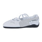 Der Puma Speedcat Ballet LTH Wns ist ein weiß-grauer Damen-Motorsport-Sneaker mit überkreuzten elastischen Riemen, einer schwarzen Sohle, einem seitlichen Puma-Logo und einem eleganten Lederdesign.