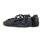 Ein Paar schwarze Puma Speedcat Ballet LTH Wns Turnschuhe mit dünnen, überkreuzten Riemen, flachen Sohlen und weißen Puma-Logos auf den Fersen und an den Seiten, von hinten und leicht zur Seite gesehen.