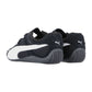 Ein Paar Puma Speedcat Summer Wns Sneakers in Schwarz mit weißen Seitenstreifen und strukturierten Gummisohlen, aus einem Winkel gezeigt, der die Rückseite und die Seite beider Schuhe hervorhebt.