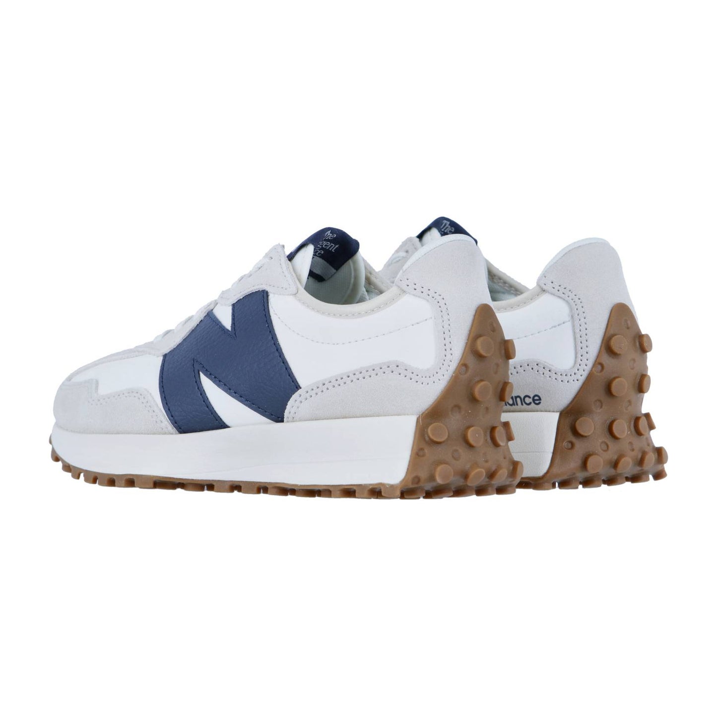 Der New Balance 327 präsentiert sich in weißem und hellgrauem Design mit auffälligen navyfarbenen N-Logos, dicker weißer Zwischensohle und brauner Gummilaufsohle mit erhabenen Punkten - eine Kombination aus retro-inspiriertem Stil und modernen Details.