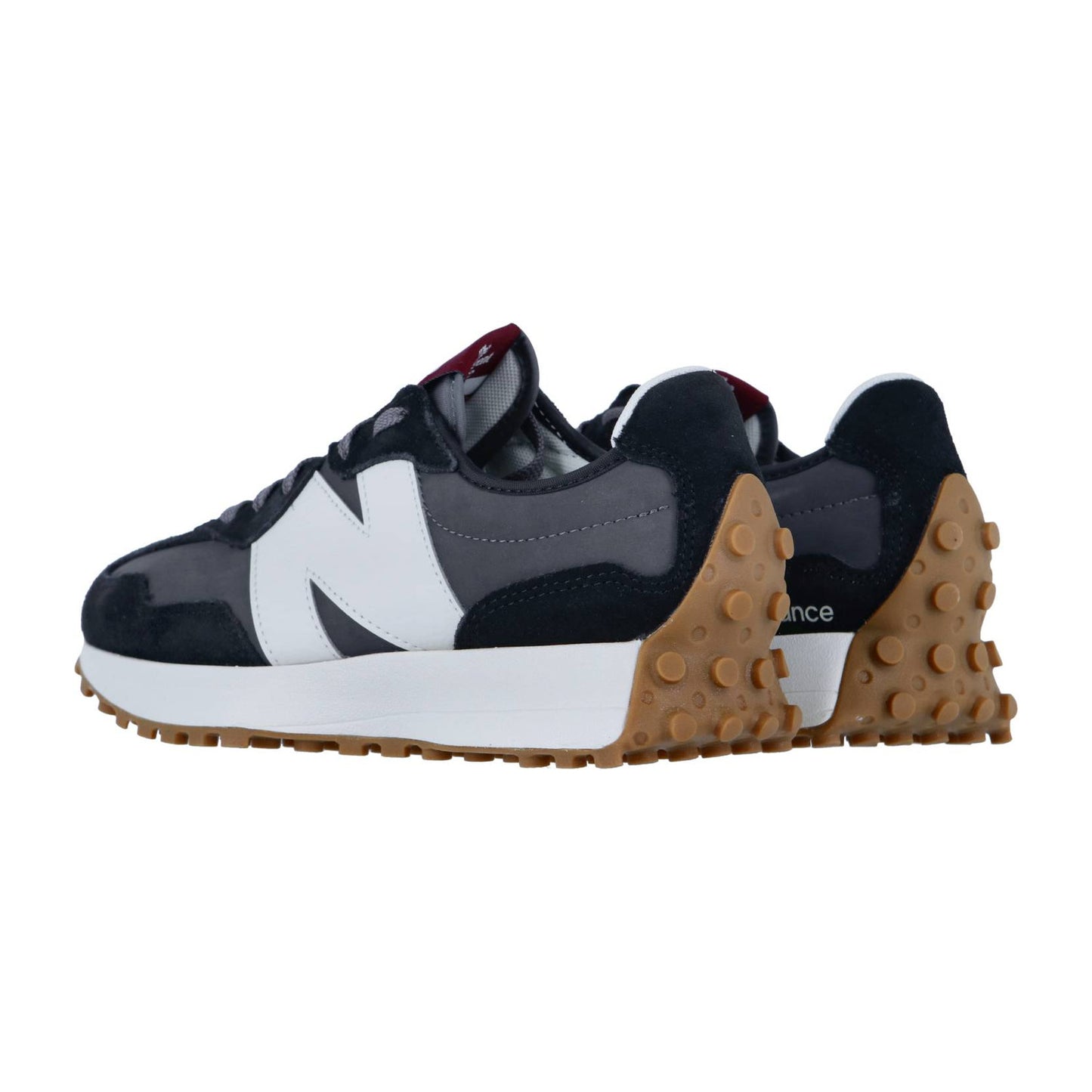 Ein Paar New Balance 327 Sneakers in Marineblau und Weiß mit Wildlederakzenten und Gummisohlen mit erhabenen runden Griffen, die schräg gezeigt werden, um ihre Seiten und Rückseiten hervorzuheben.