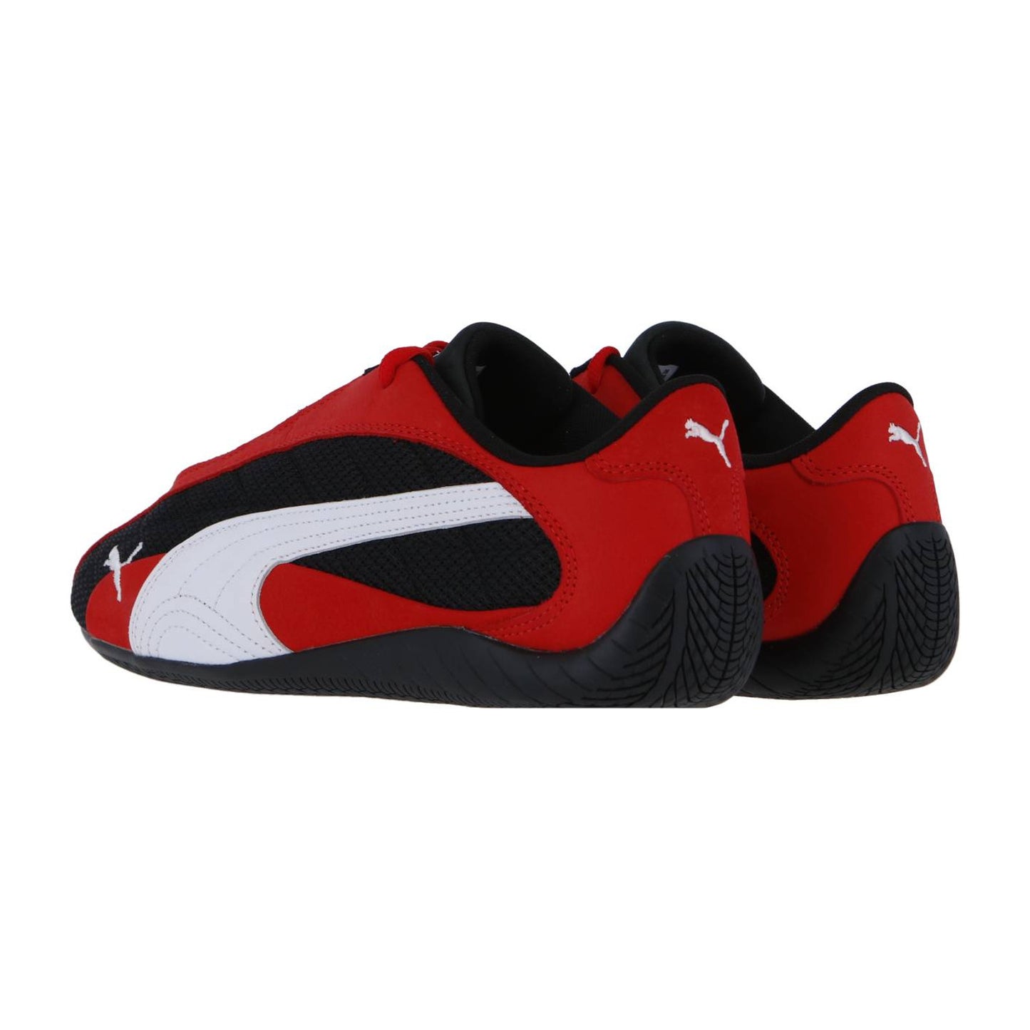 Ein Paar Puma Speedcat Plus Sneakers in Rot und Schwarz mit weißen Puma-Logos, vom Rennsport inspirierten Akzenten, einem schlanken, flachen Design und strukturierten schwarzen Sohlen, dargestellt vor einem schlichten weißen Hintergrund.