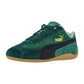 Der Puma Speedcat Sneaker hat grünes Wildleder, einen schwarzen Seitenstreifen, ein goldenes Puma Logo, grüne Schnürsenkel und eine Gummisohle für einen vom Motorsport inspirierten Style.