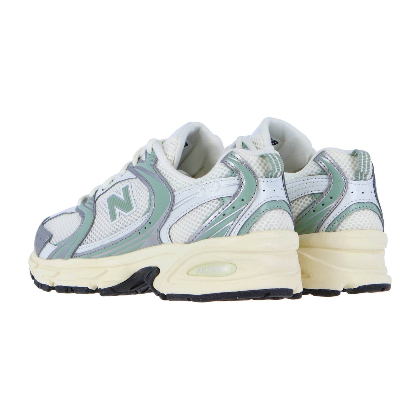 Ein Paar New Balance U530V1 Sneaker in Weiß und Hellgrün mit Mesh und Leder, ABZORB-Dämpfung, klobiger cremefarbener Zwischensohle und schwarzer Laufsohle, gezeigt von hinten und von der Seite in einem Winkel.