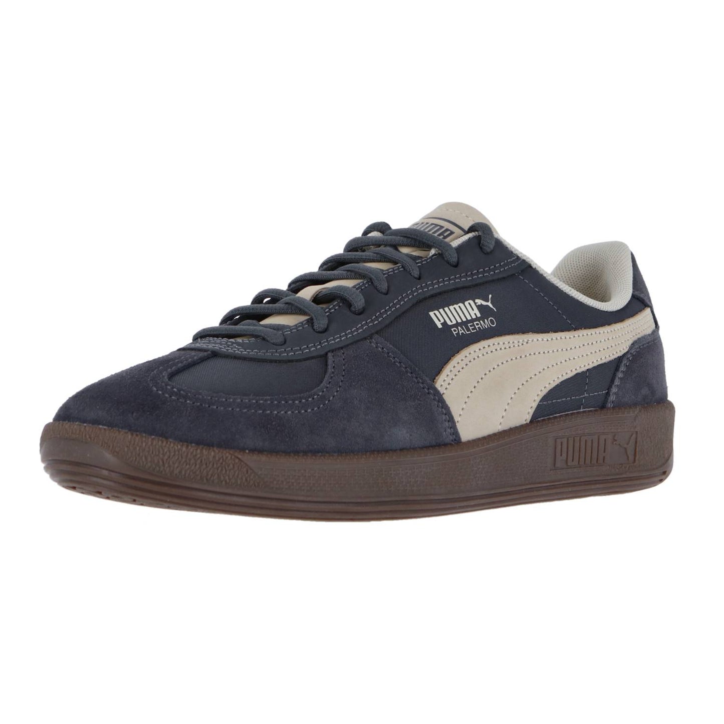 Der Puma Palermo Pop ist ein Retro-Sneaker in Marineblau und Beige mit einer Zehenkappe aus Wildleder, hellbraunen Streifen und einer braunen Gummisohle. Er ist Teil der Terrace-Kollektion und hat ein weißes Palermo und Puma Branding an der Seite.